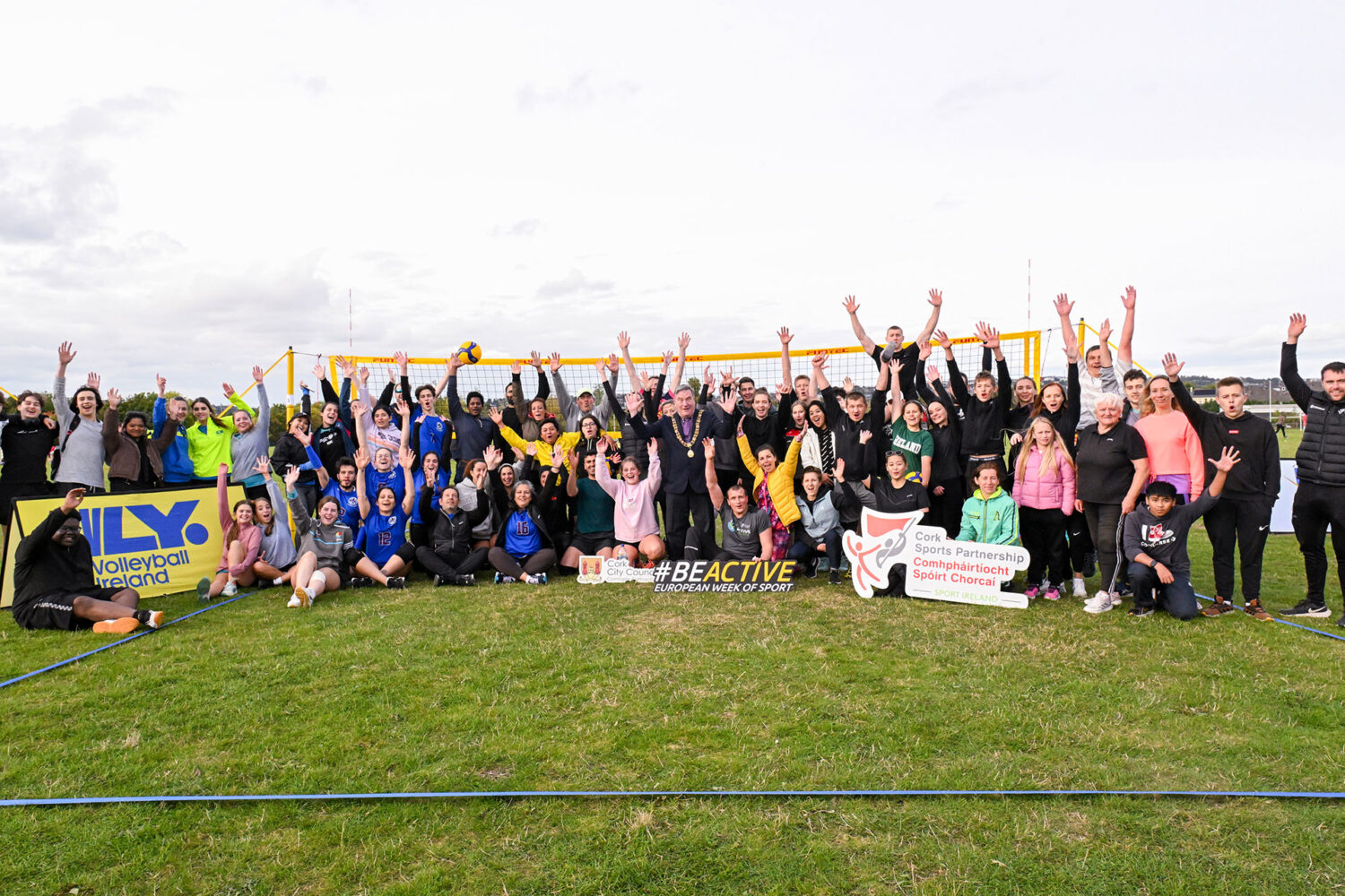 Group of people at Tramore Valley Park waving by a volleyball net.